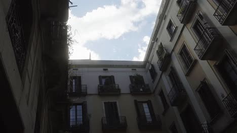 a neighborhood of barcelona, spain, with bright clouds and birds in a low-angle shot