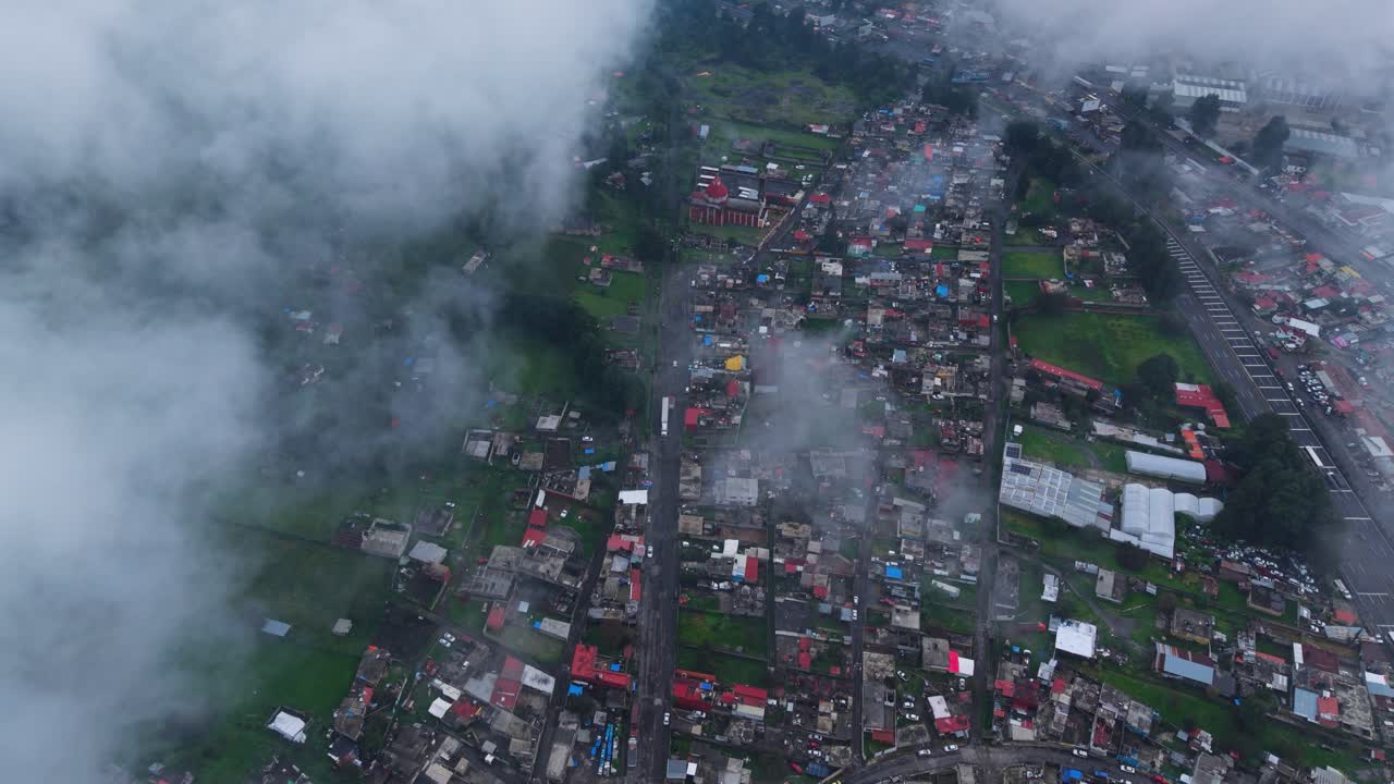 High-altitude drone shot of a village in state of Morelos, among clouds
