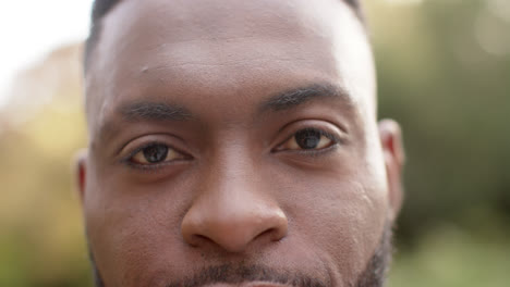 Retrato-De-Cerca-Un-Hombre-Afroamericano-Feliz-Sonriendo-En-El-Jardín,-En-Cámara-Lenta