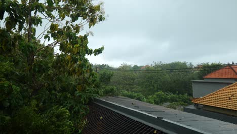 wide shot from a balcony of heavy rain in uluwatu, bali