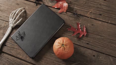 video del esqueleto de halloween mano, cuaderno y decoraciones con espacio de copia en fondo de madera