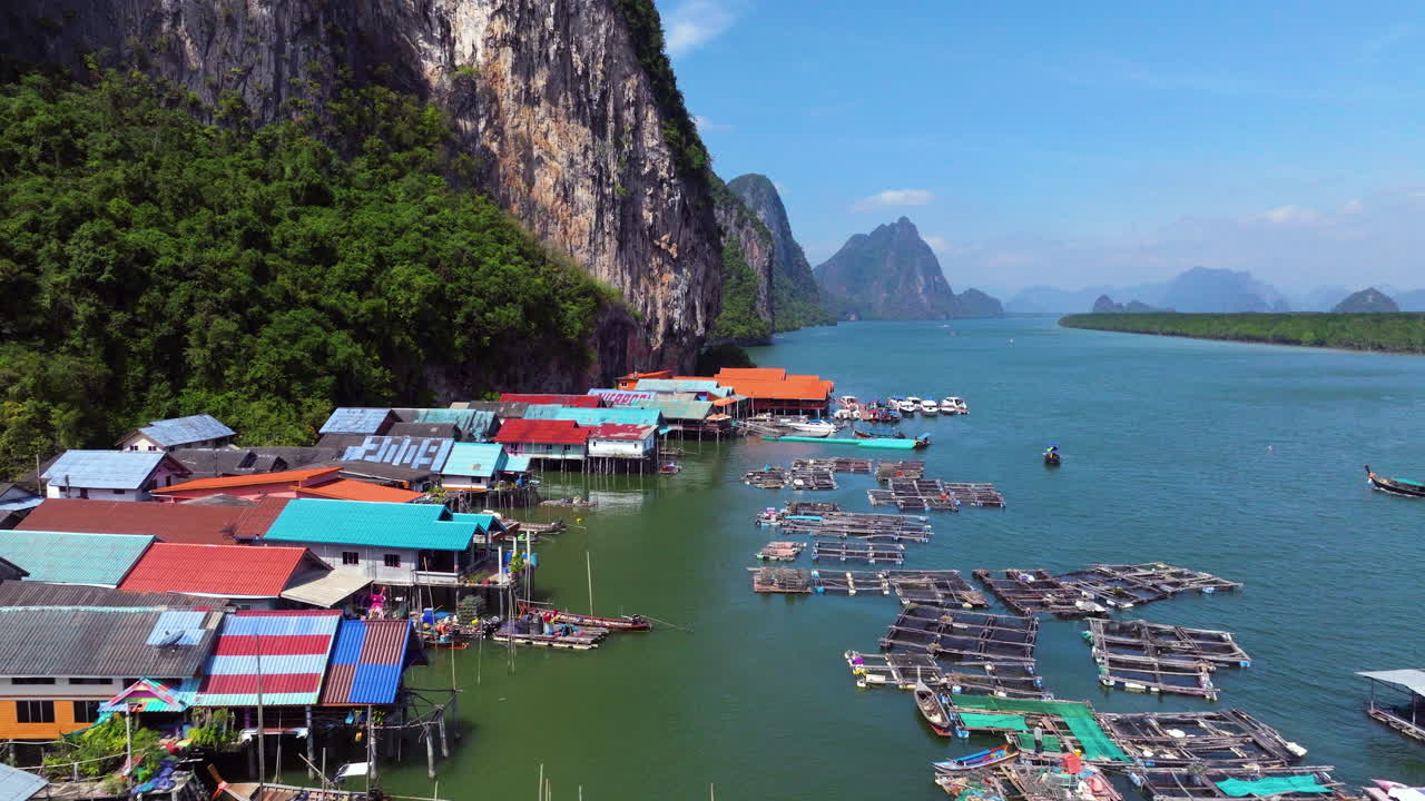 Aerial View Of Koh Panyee Floating Village In Thailand's Phang Nga Bay, With Colorful Stilt Houses And Fishing Nets Along Limestone Cliffs
