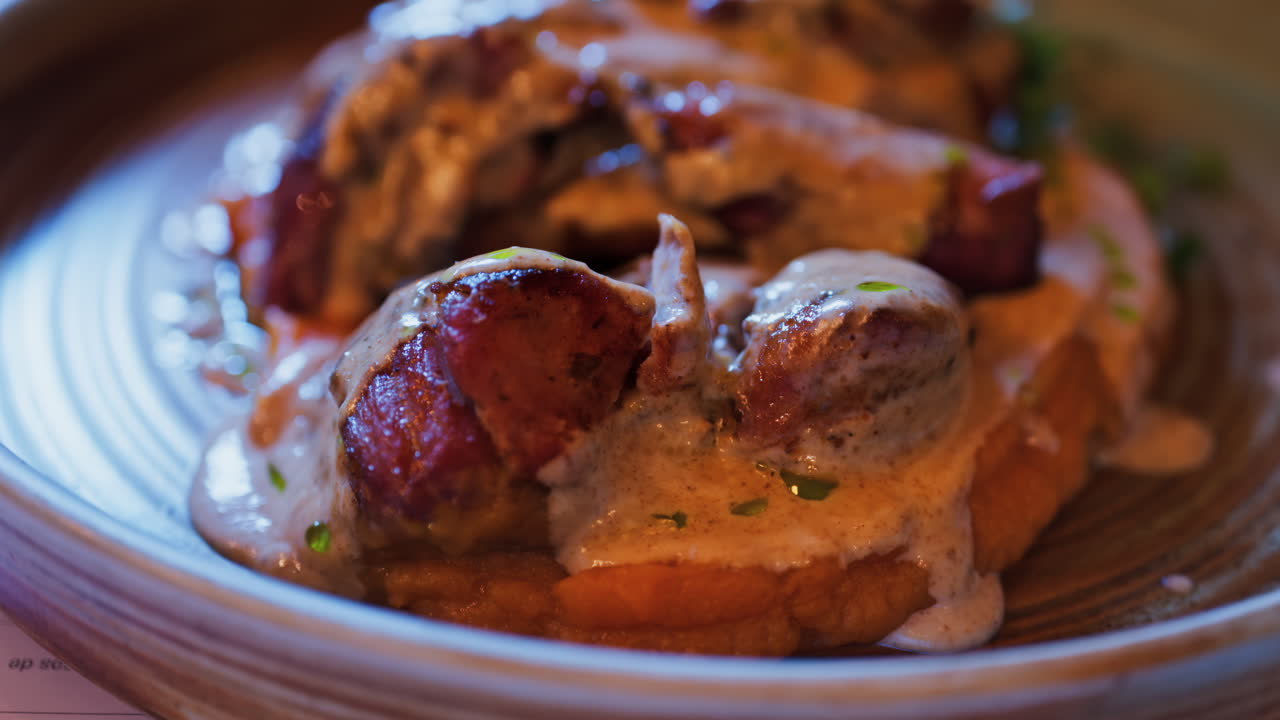 Close up of pork meat over a bed of a sweet potato puree at a restaurant
