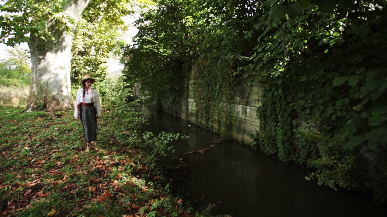 루마니아 소녀는 해안에서 흐르는 개울을 감상합니다.