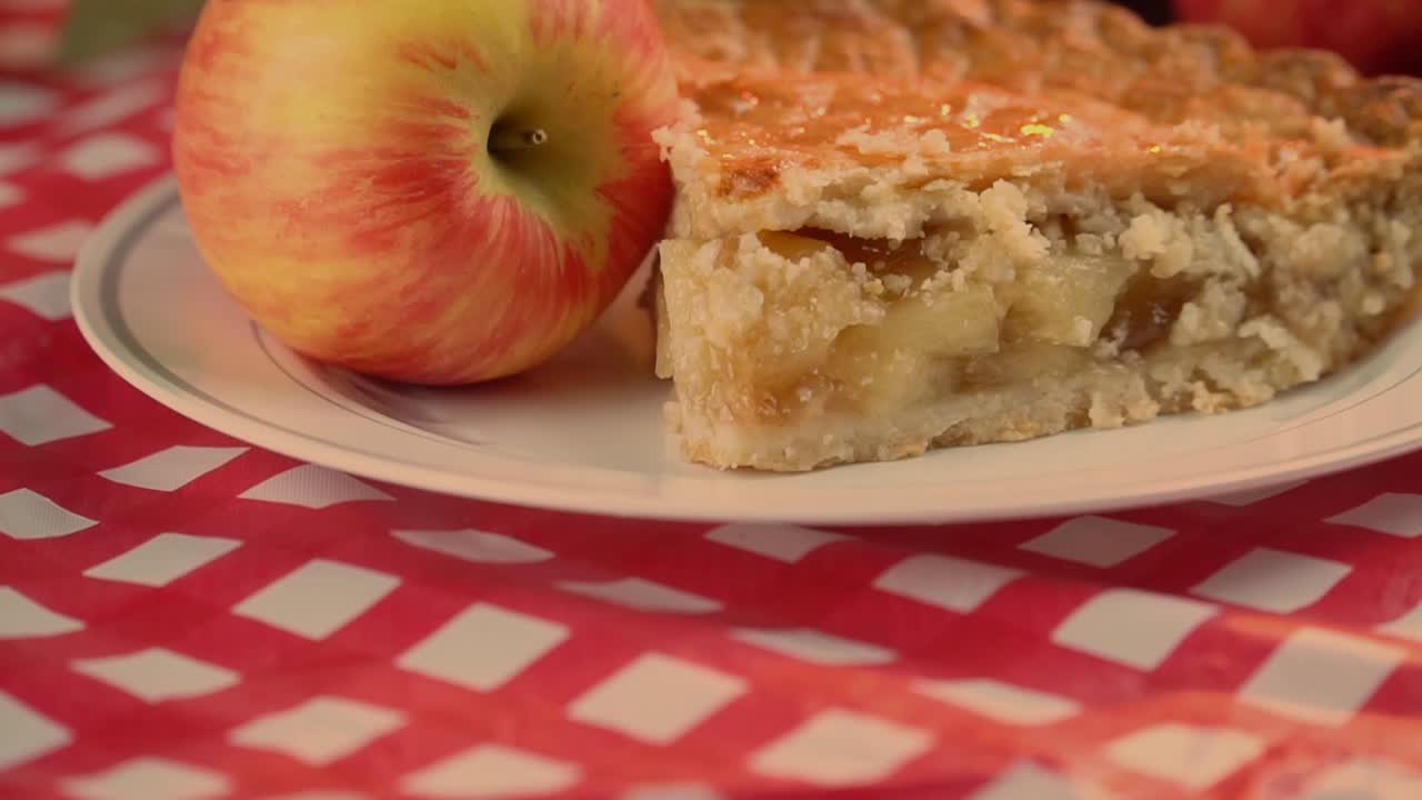 deliciosa tarta de manzana hecha con manzanas crujientes de miel sobre un paño de cuadros rojo y blanco