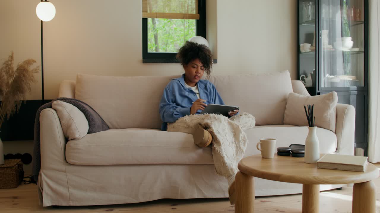 Young Woman Using Tablet on a Sofa