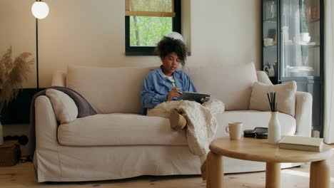 young woman using tablet on a sofa