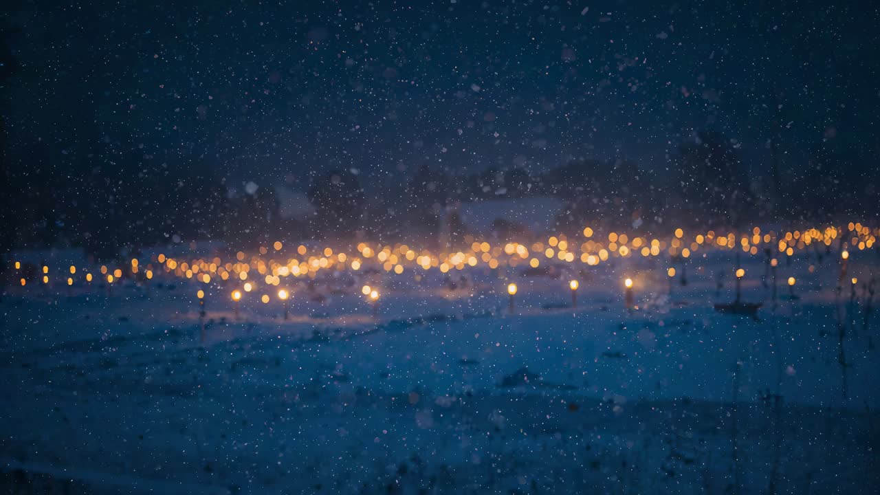 Glowing band of warm lights shimmering over snowy plain at night, cold air causing snowfall