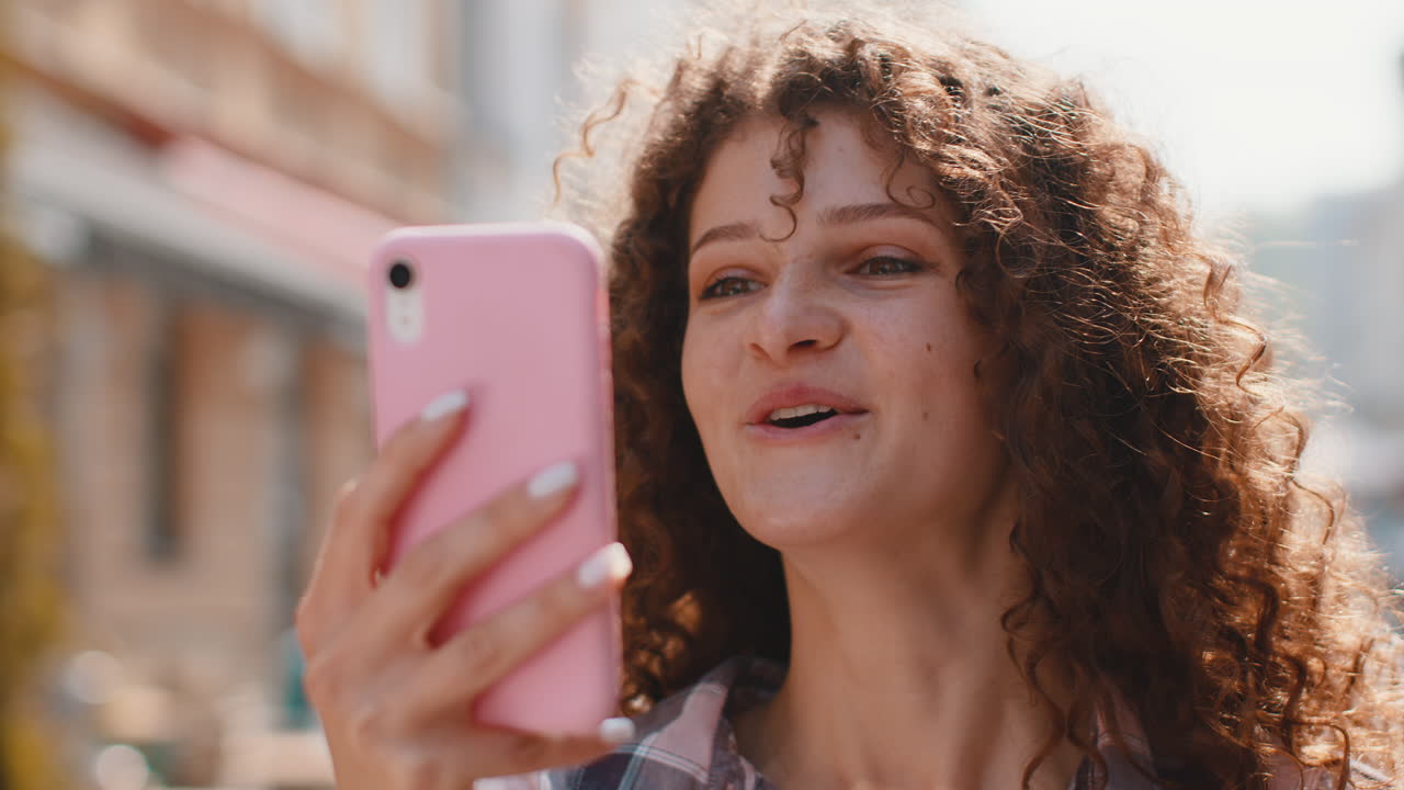 feliz ganadora emocionada mujer joven usa teléfono inteligente celebrando la victoria buenas noticias de mensaje en la calle de la ciudad