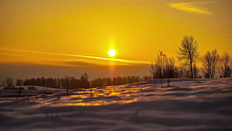 a golden sunrise over a snowy, winter wilderness - time lapse