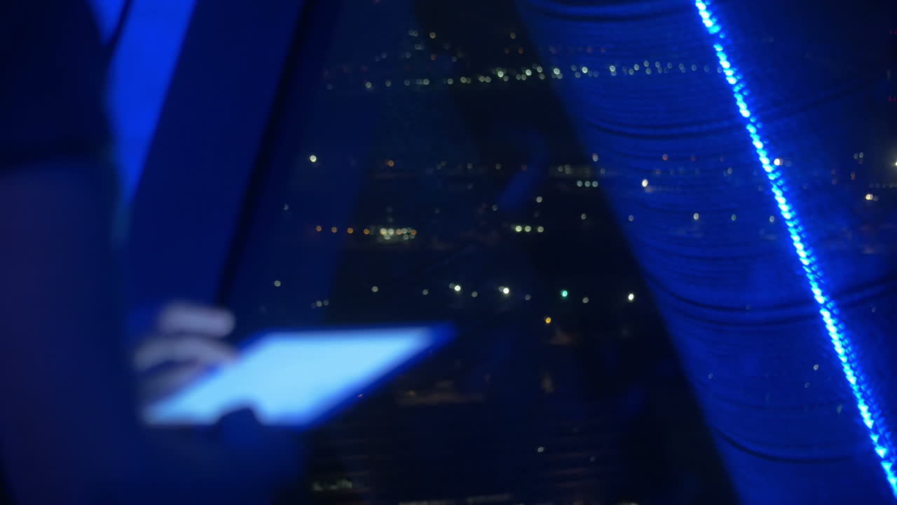 mujer usando el touch pad junto a la ventana por la noche