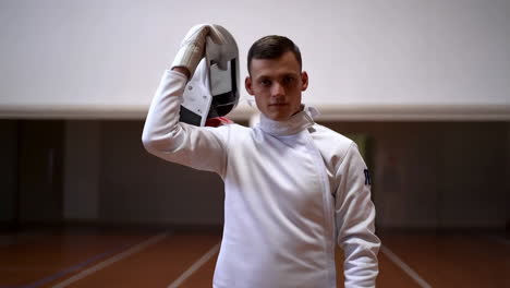 fencer removes his mask after training