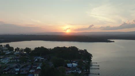 drone footage flying over lake macquarie near bonnells bay in new south wales, australia during sunset.