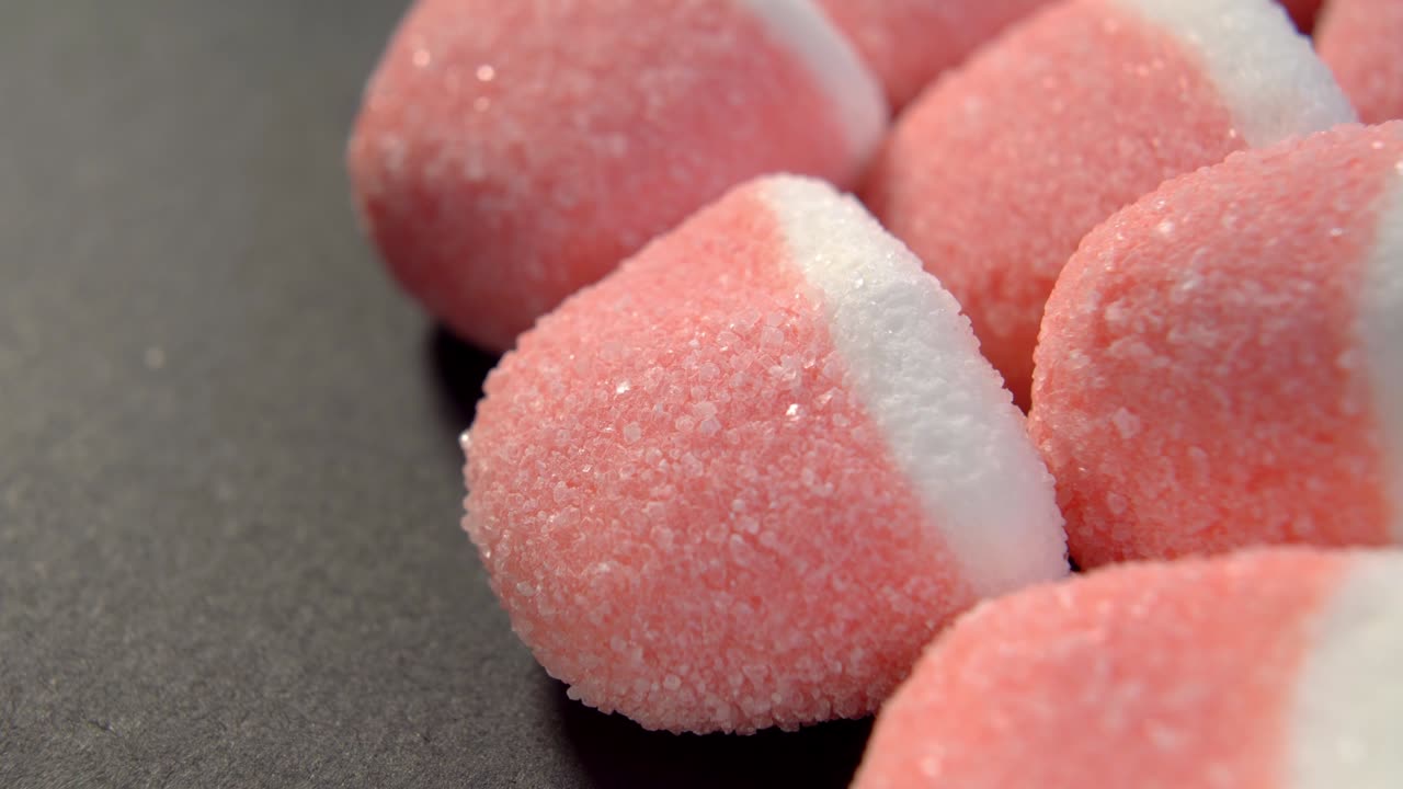 핑크색 백색 설탕 마말라드 캔디 검은 종이 배경에 은 캔디 젤리 트리트 매크로
