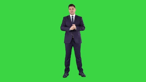 handsome businessman looking in camera and talking on a green screen, chroma key