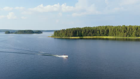 Panoramic aerial of a boat driving in the lakeland archipelago, summer in Finland