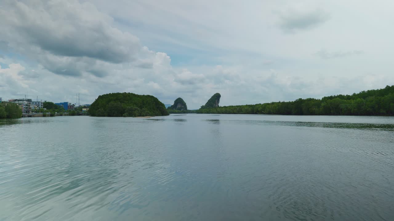 화창한 날 강 정박지 옆 태국 남부 크라비 마을에 있는 도시 숲과 암석 형성의 4k 영화적 풍경 영상