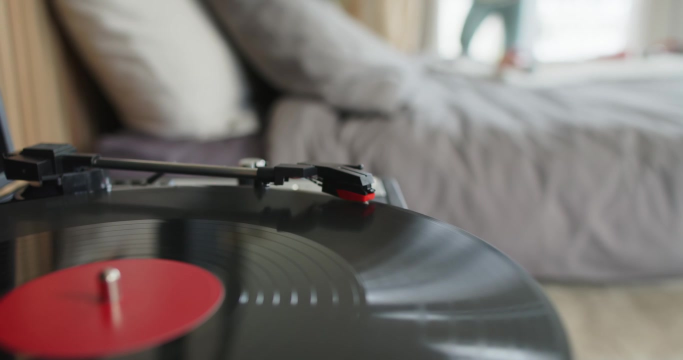 Braccio del giradischi che si muove verso l'interno sul vinile che gira dopo il contatto dello stilo, riproducendo musica in camera da letto
