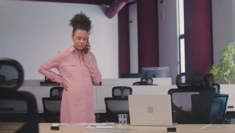 Pregnant-Woman-Talking-On-Her-Mobile-Phone-And-Caressing-Her-Belly-While-Working-In-The-Office-6
