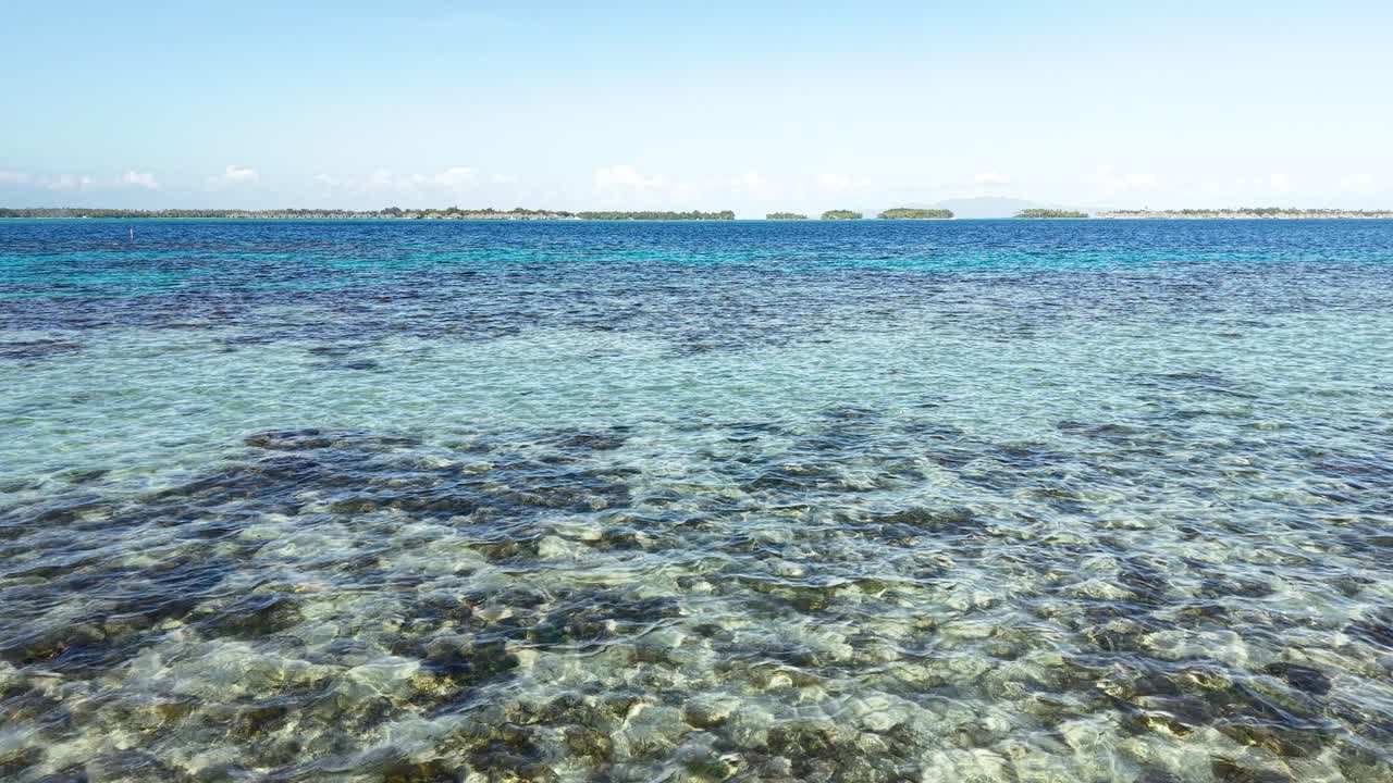 Drone Shot of Bora Bora Island Lagoon, French Polynesia. Flying Above Coral Reefs and Clear Water