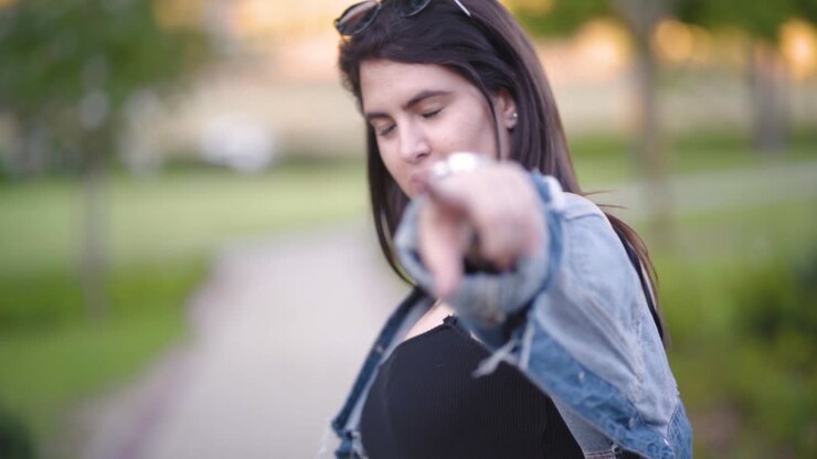 Una ragazza sorride e indica la fotocamera