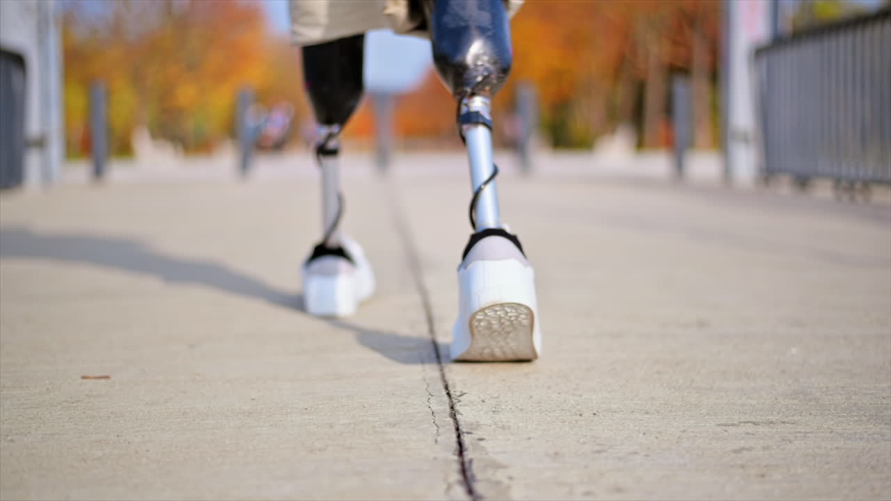 Slow motion view of a walking man with prosthetic legs and white sneakers