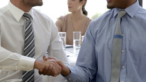 businessman handshaking in front of businesswoman