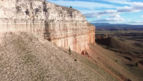 aerial approach toward a cliff face in the red canyon of teruel