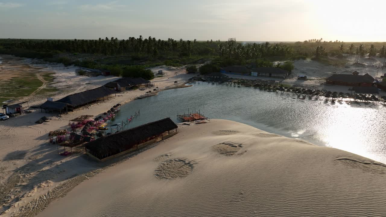 Orbit drone shot of hotel resort in Lencois Maranhenses National Park at sunset in Maranhao state, northeastern Brazil