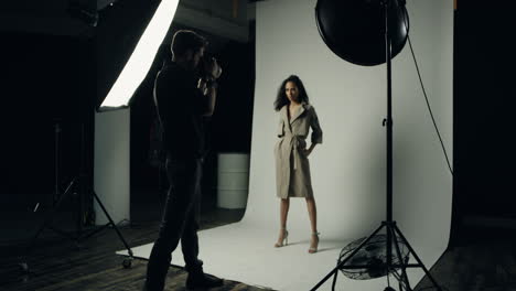 african american female model posing to the camera of the man photographer in the studio with spotlight