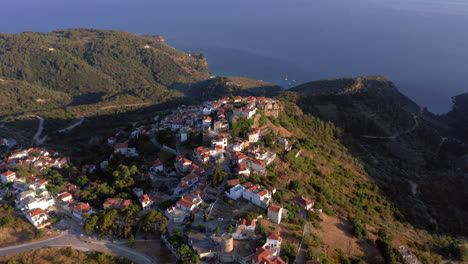 desde el aire: vista panorámica del avión no tripulado sobre el hermoso pueblo antiguo de la isla de alonnisos en sporades, grecia durante la puesta del sol