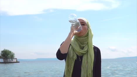 woman drinking water at the beach