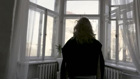 woman looking out a bay window