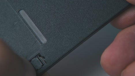 los dedos mueven partes de la vieja disquete de disco macro