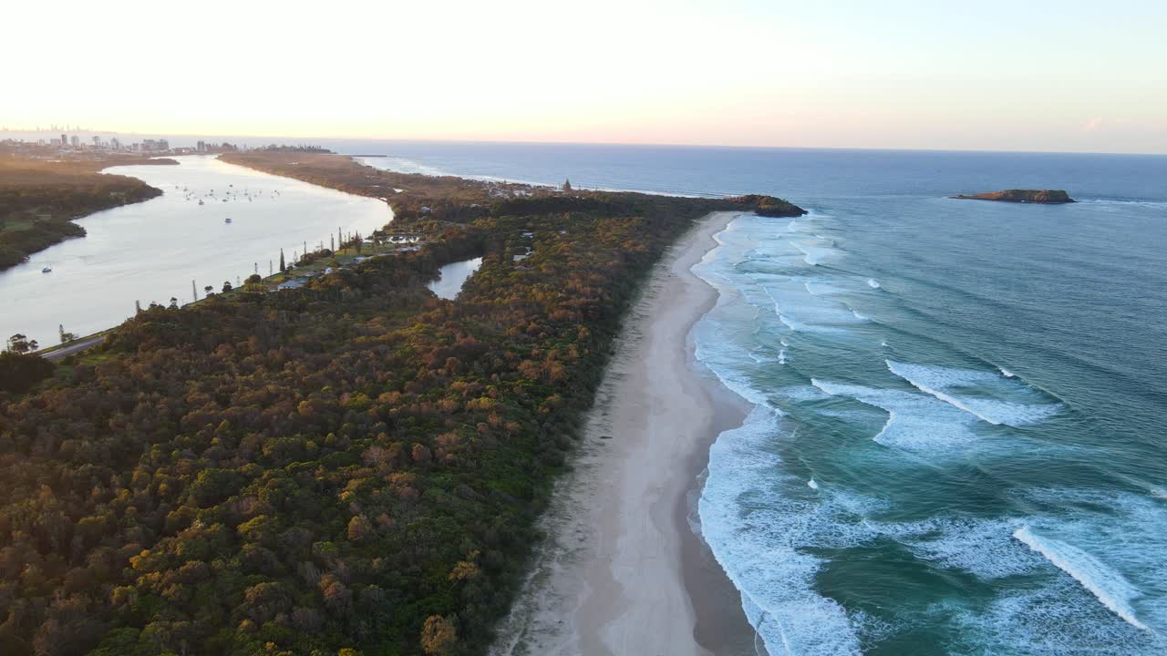 Onde dell'oceano a Dreamtime Beach lungo la baia di Wommin - Fiume Tweed e Fingal Head al tramonto nel Nuovo Galles del Sud, Australia.