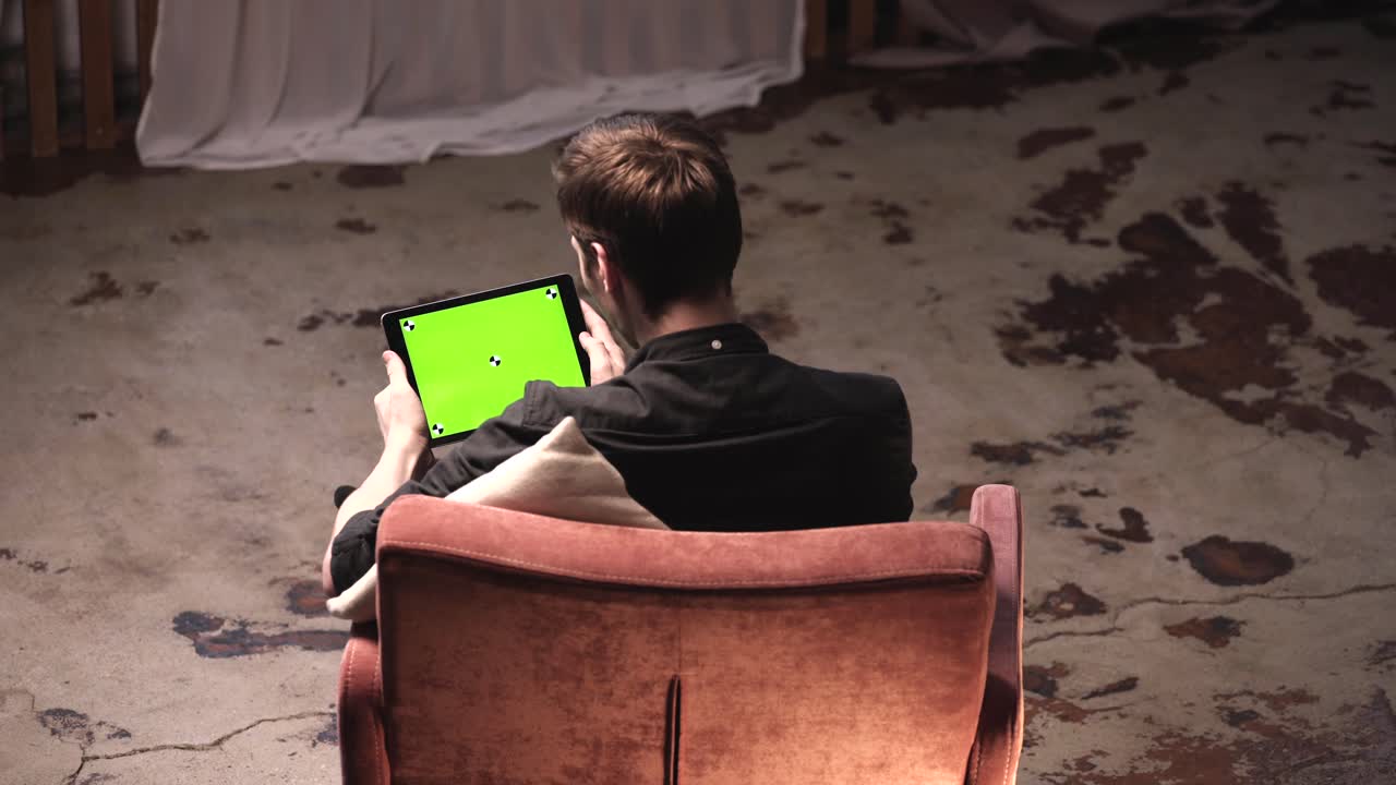 hombre usando una tableta con una pantalla verde