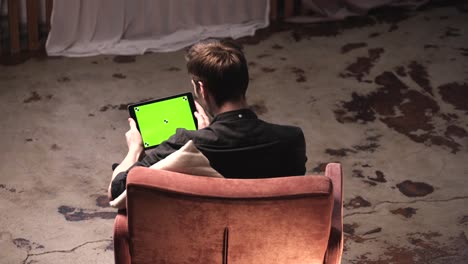 man using a tablet with a green screen