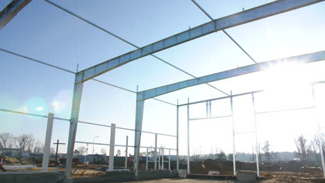 sol sobre un sitio de contracción con pilares de cimientos de estructura montados y grúa de excavadora, nueva zona de desarrollo residencial en el campo