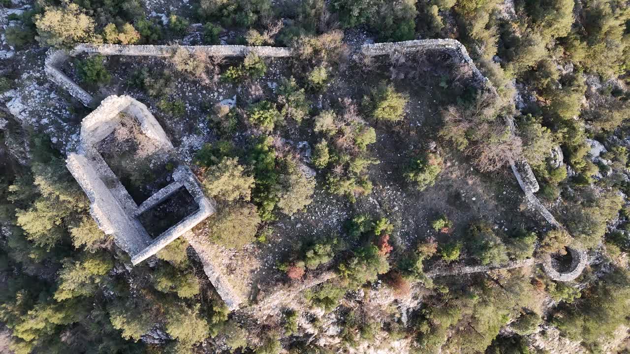 vista de avión no tripulado de la bandera en la parte superior de las ruinas del castillo entre los árboles en la cima de la montaña, castillo de belenkeşlik, turquía