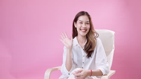 Cheerful-pretty-girl-sitting-and-smiling-looking-to-camera-indoors