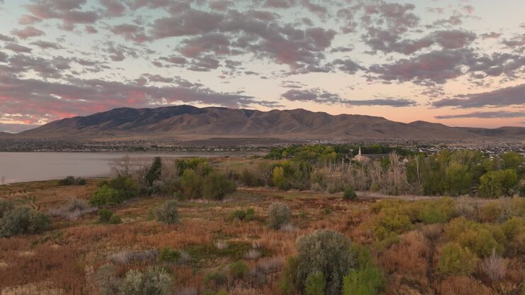 Sorvolo aereo della costa del lago Utah che rivela una chiesa comunitaria a Saratoga Springs all'alba