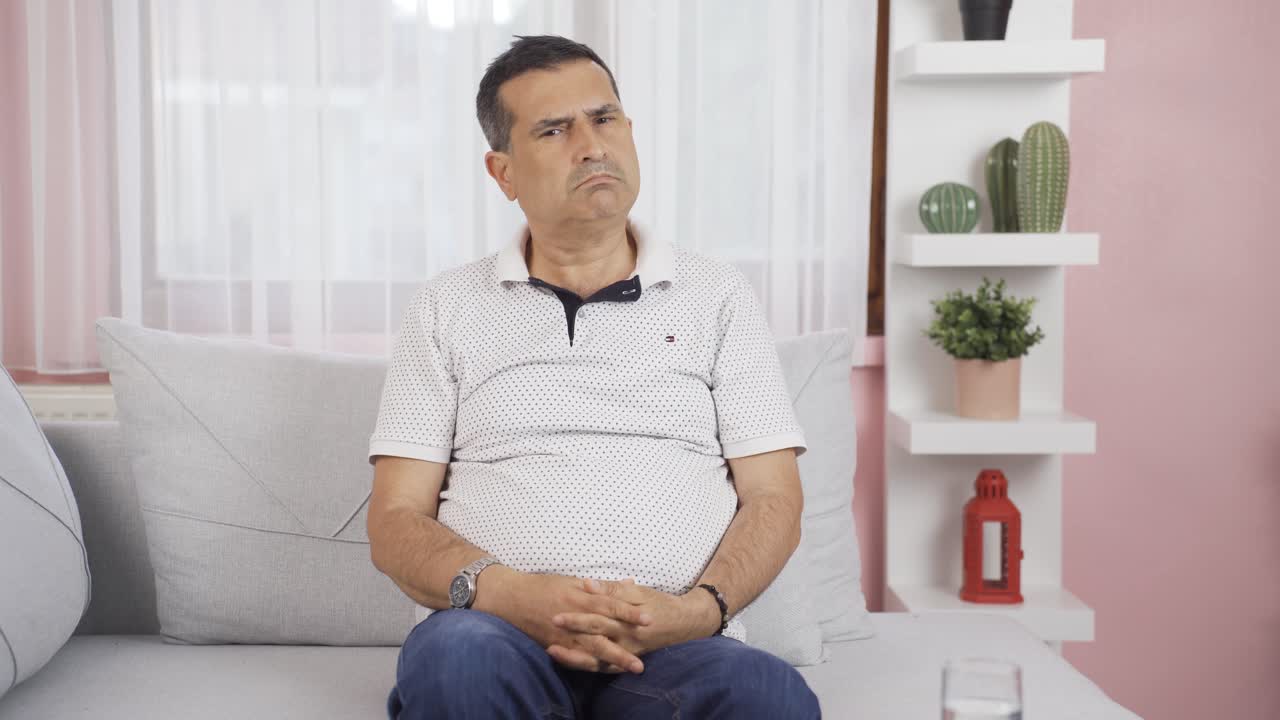Uomo con espressione negativa che guarda la telecamera. Uomo dall'aria contrariata.