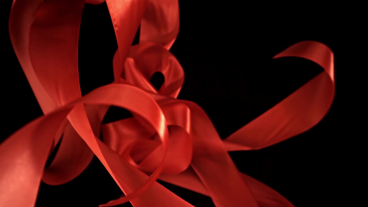 Elegante rote Satinbänder wirbeln vor dunklem Hintergrund