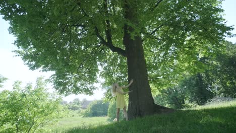 Happy beautiful young girl dancing of freedom in summer park with trees in the background.