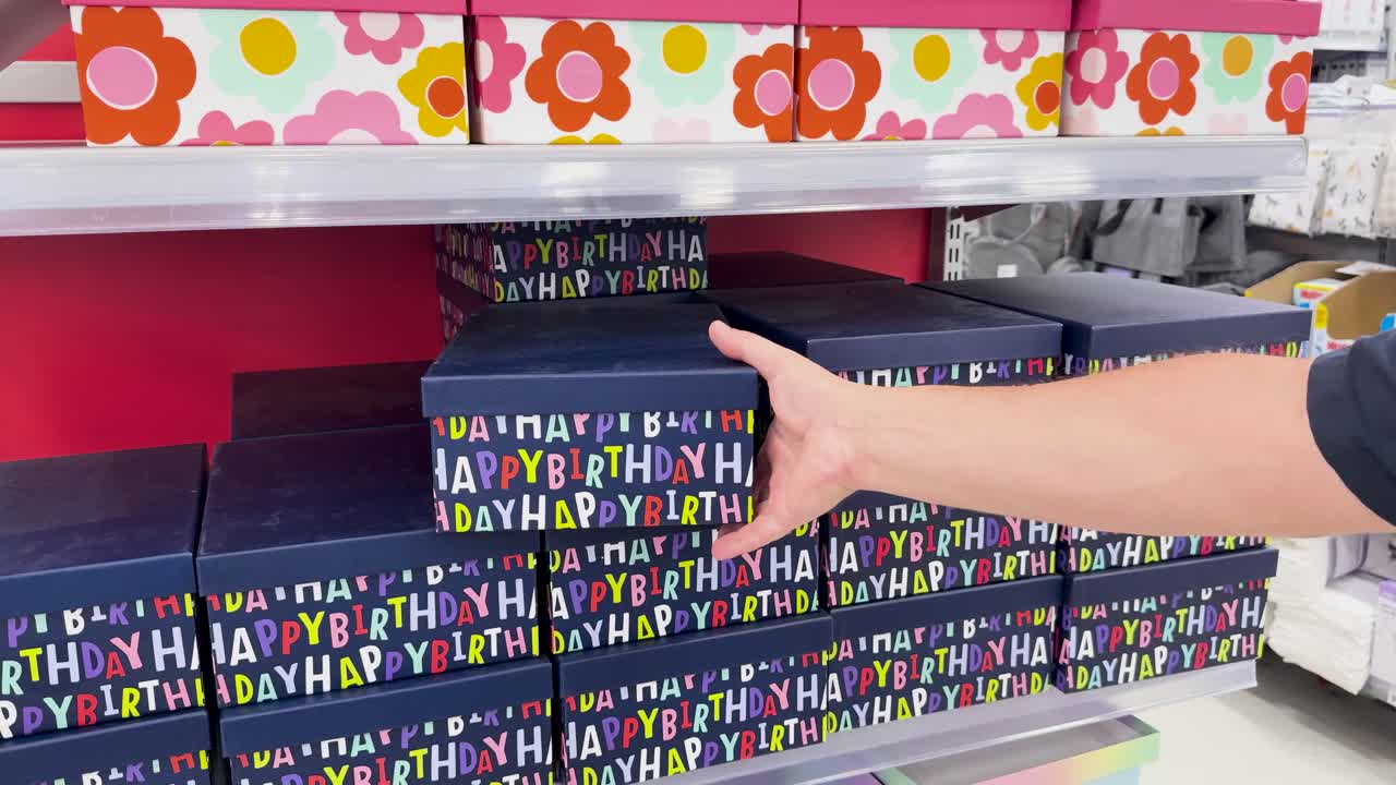 persona eligiendo una caja de regalos de cumpleaños colorida