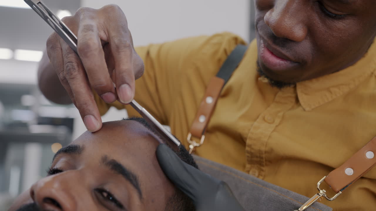Close-up of a Barber Shaving a Man's Head