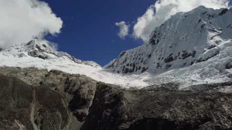 vista aérea de una ladera nevada con montañas en el fondo en un día soleado en los andes