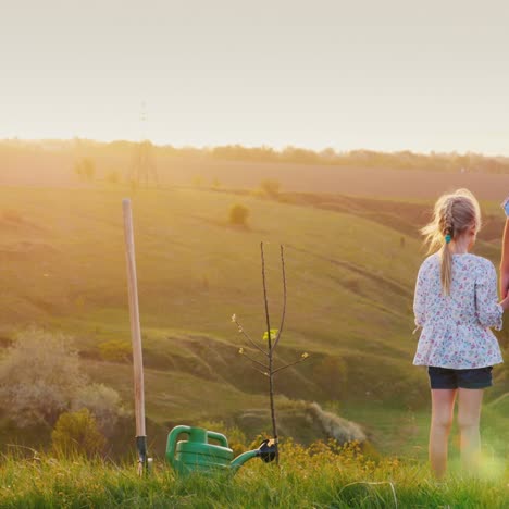 Vater-Und-Tochter-Freuen-Sich-Gemeinsam-Auf-Den-Horizont,-Wo-Die-Sonne-Untergeht