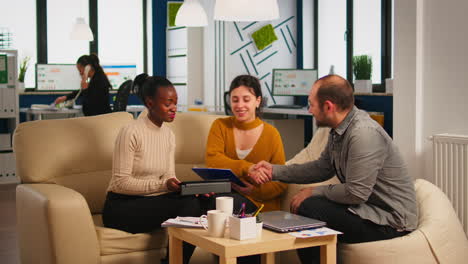 black businesswomen shaking hands with manager sitting on couch