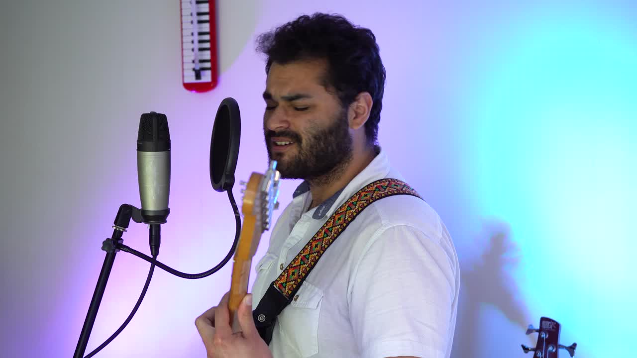 músico apasionado canta mientras toca su guitarra en el estudio
